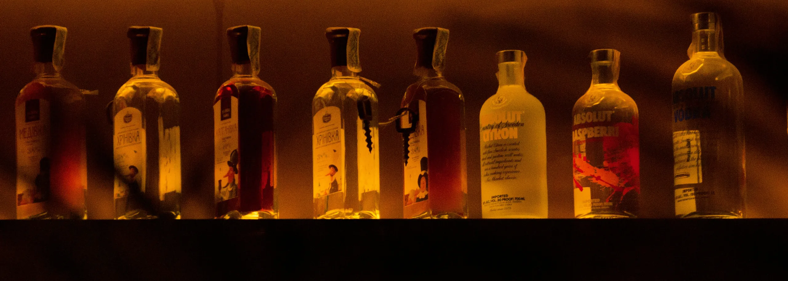 Backlit spirit bottles along the bar at Julia's Mexican Restaurant