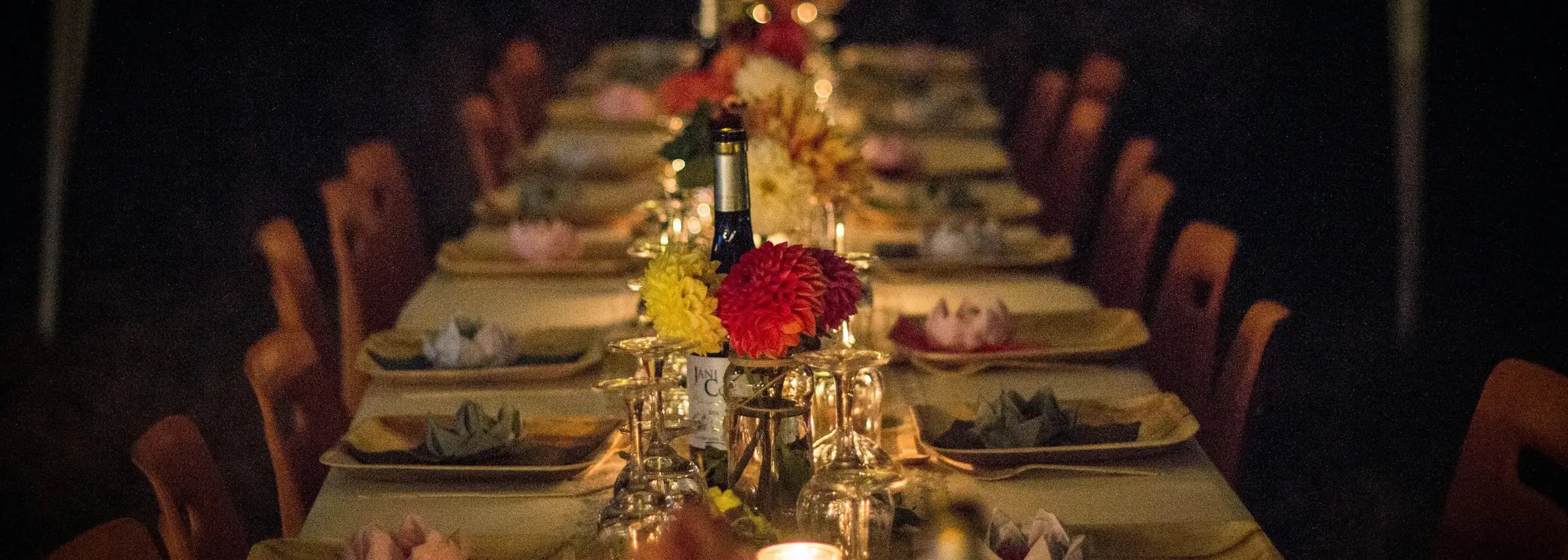 A long table set with candles and flowers for a private dinner