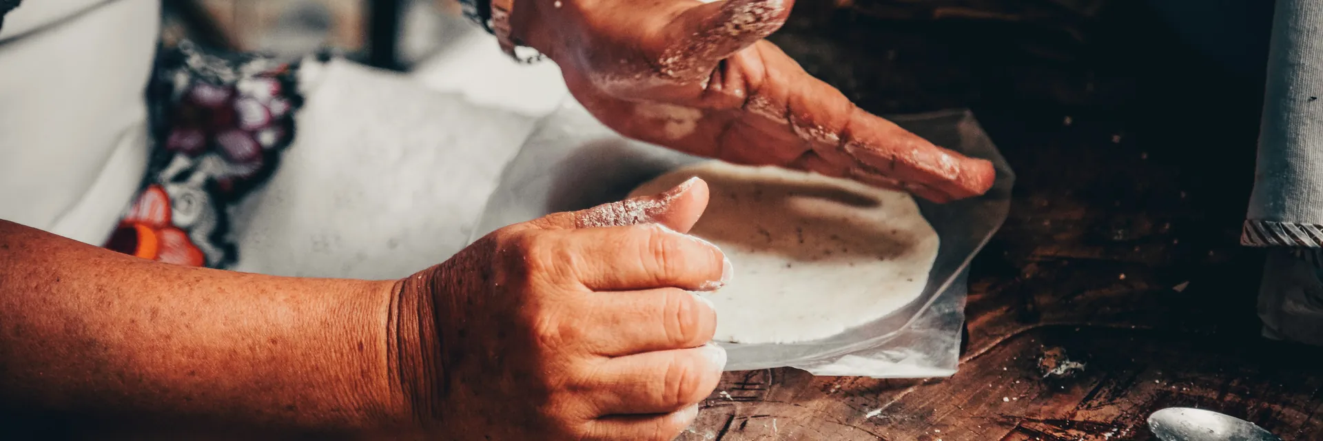 Masa being pressed by hand into a fresh tortilla