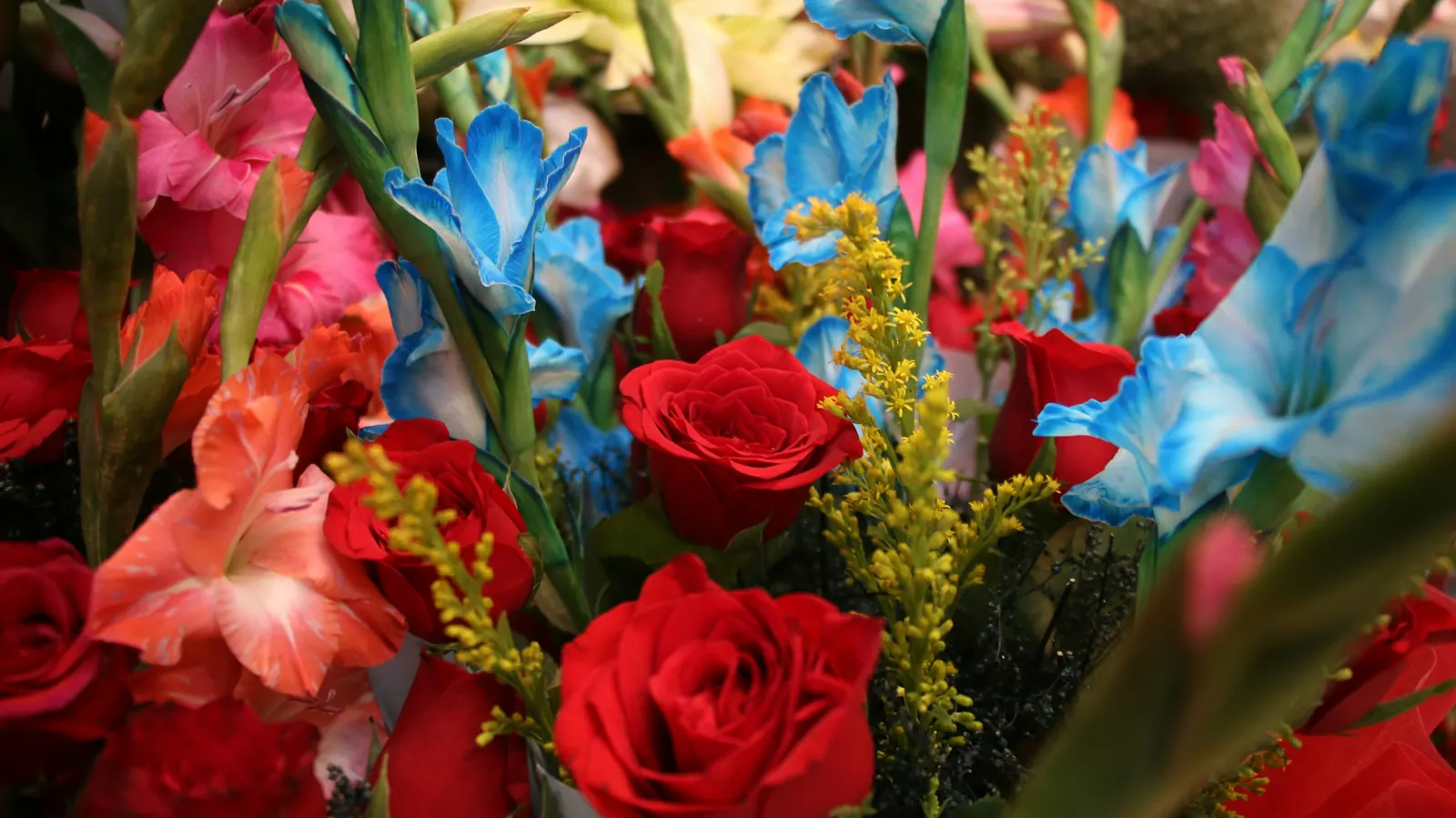 A bouquet of red roses and bright gladiolas