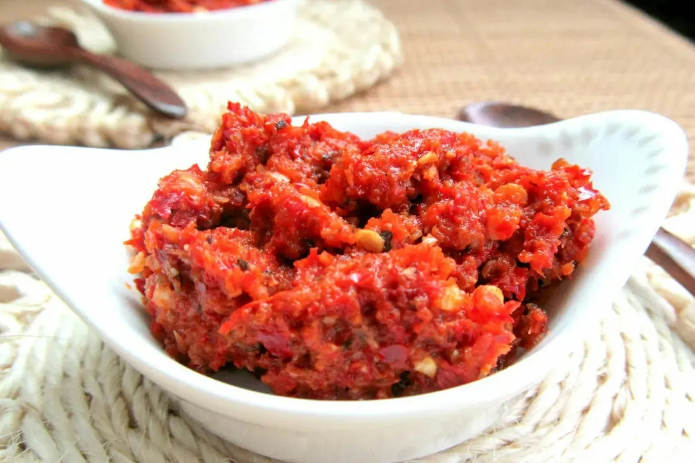 A white bowl holding a coarse deep red paste