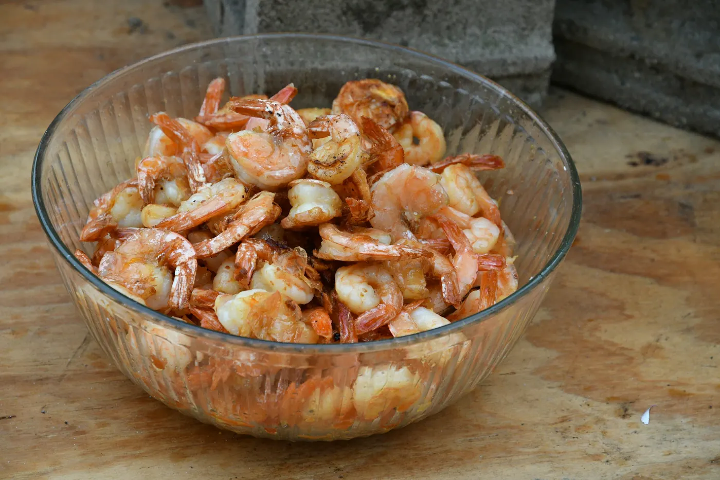 A glass bowl filled with cooked peeled shrimp