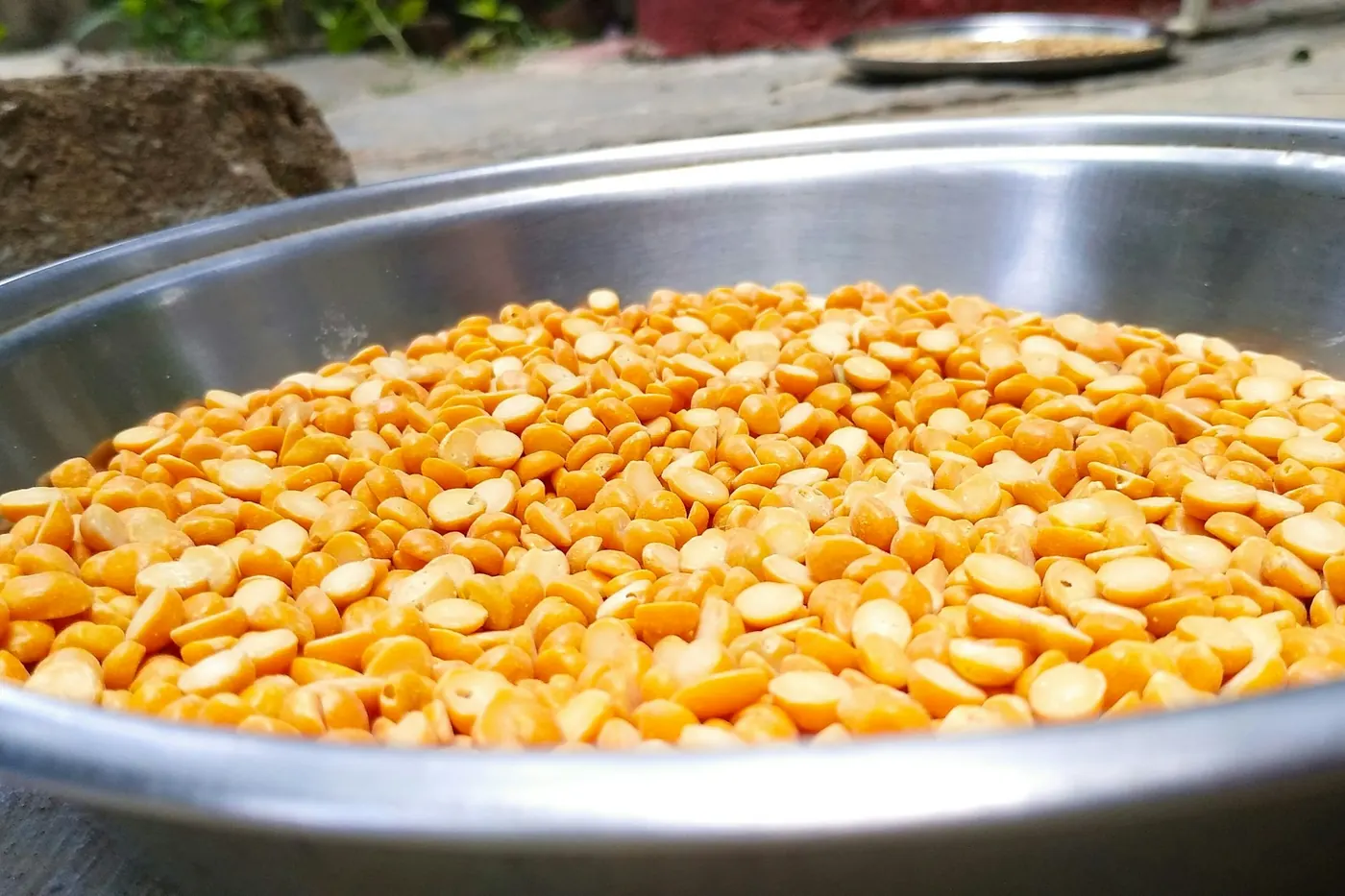 A large metal bowl filled with corn kernels being prepared