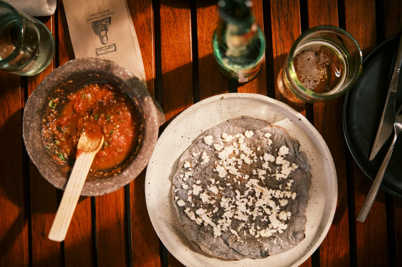 A bowl of smooth dark refried beans topped with crumbled white cheese