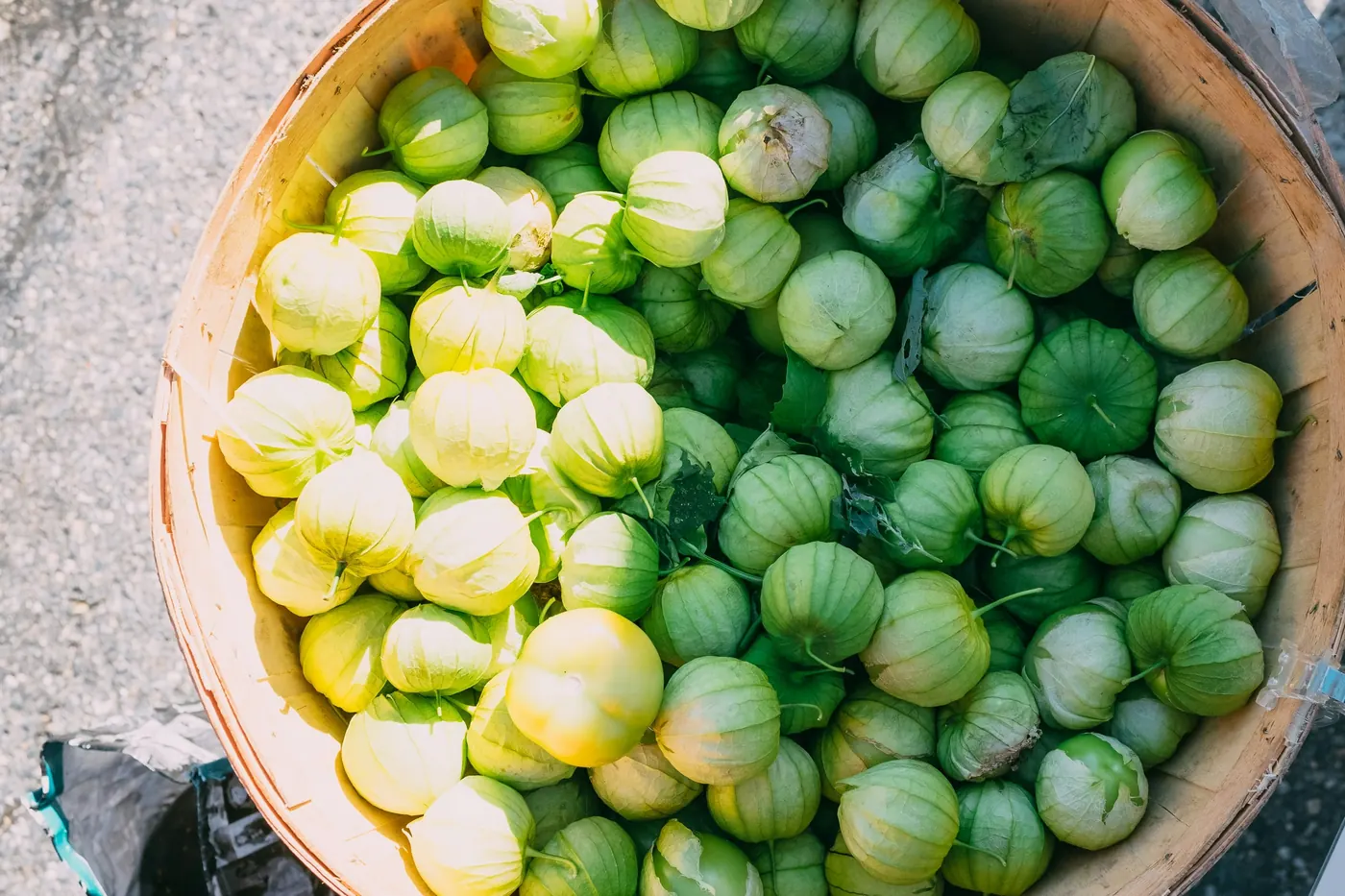 A wide bowl filled with small green tomatillos