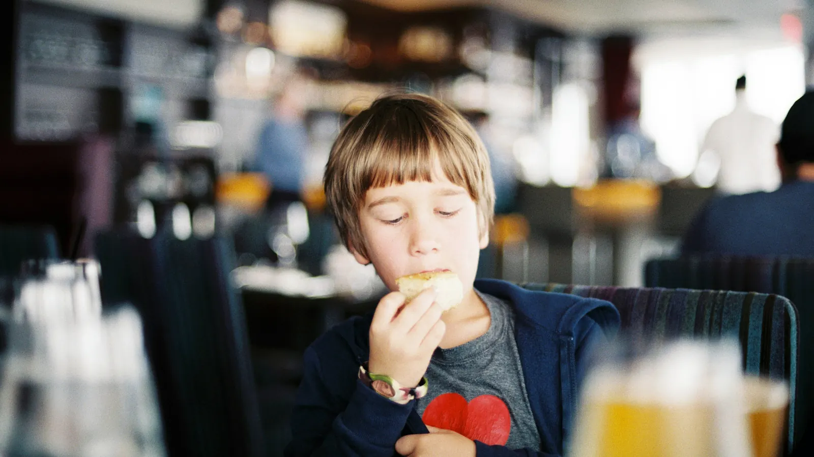 A young child eating at a table in a restaurant