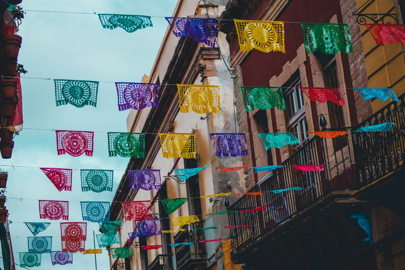 A colonial-era street lined with painted buildings and strung with banners