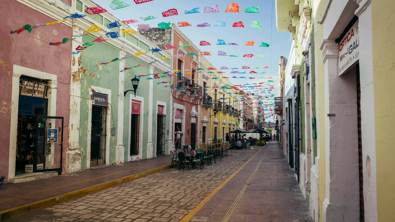 A wide colonial street lined with pastel-painted buildings