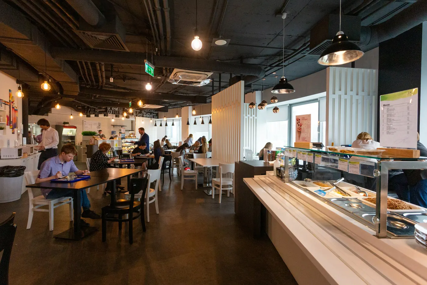 A bright counter-service restaurant with customers ordering