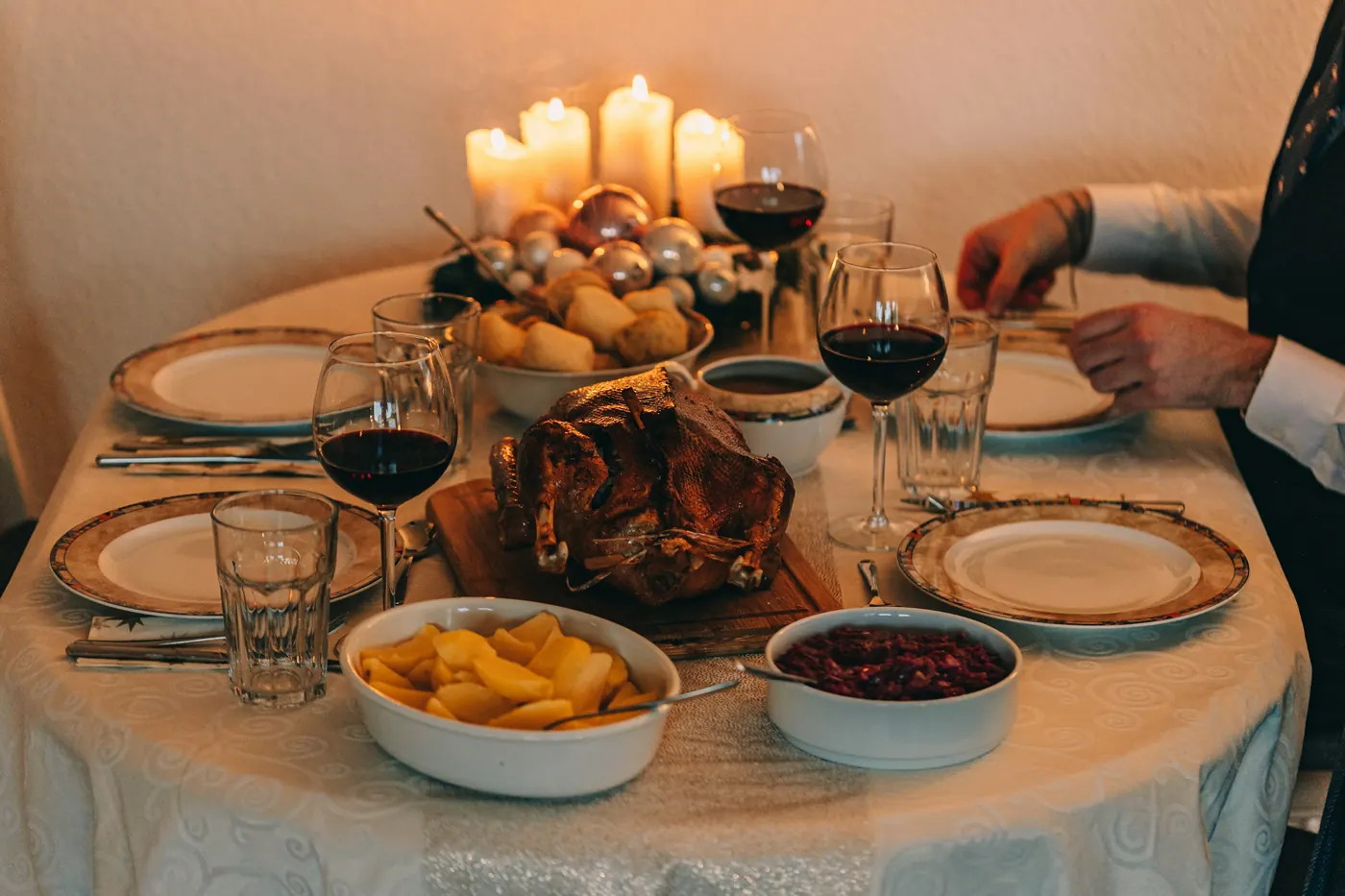 A laid table with candles, glasses and serving dishes