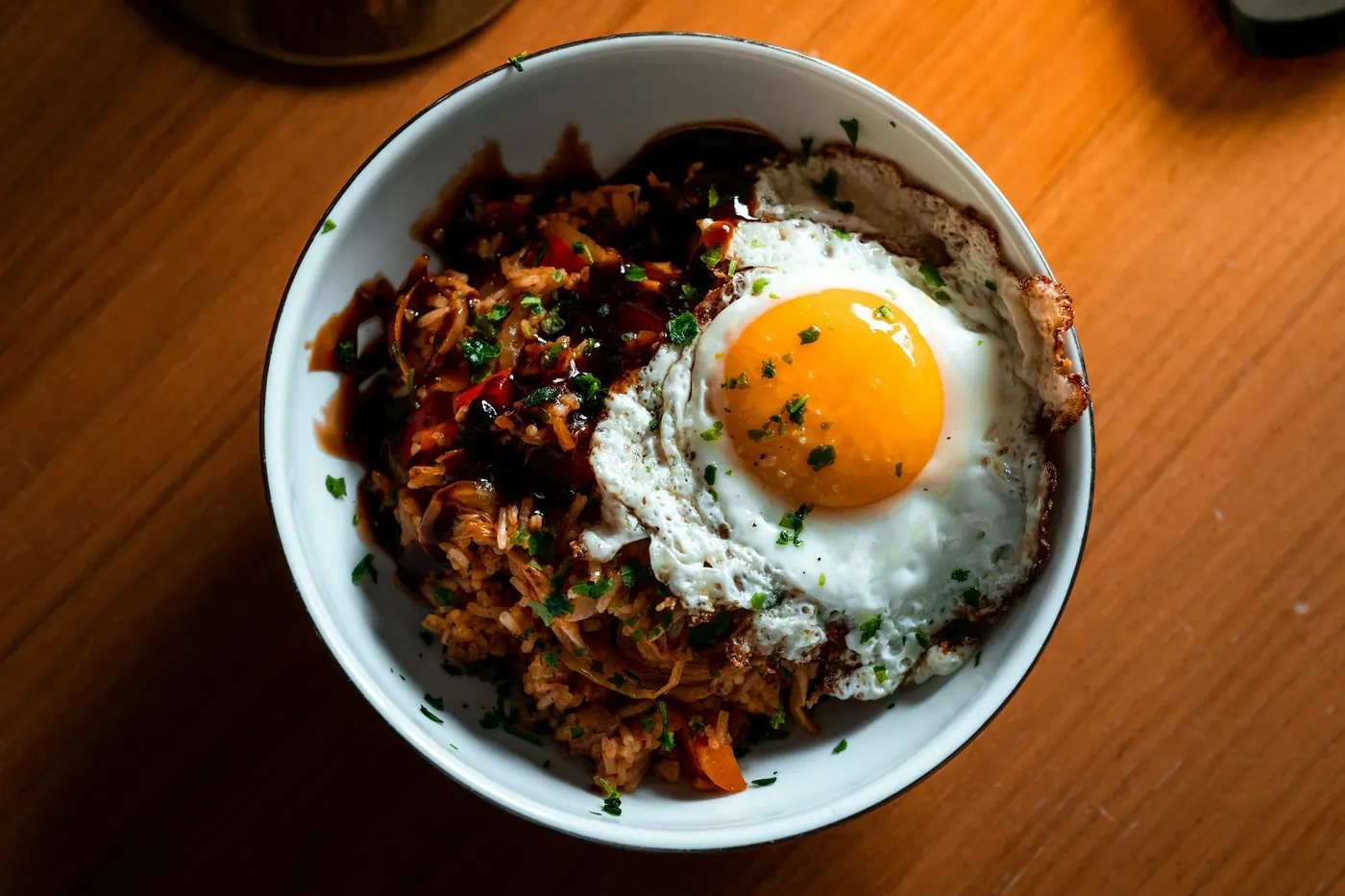 A fried egg sitting on top of sauced tortilla pieces in a bowl