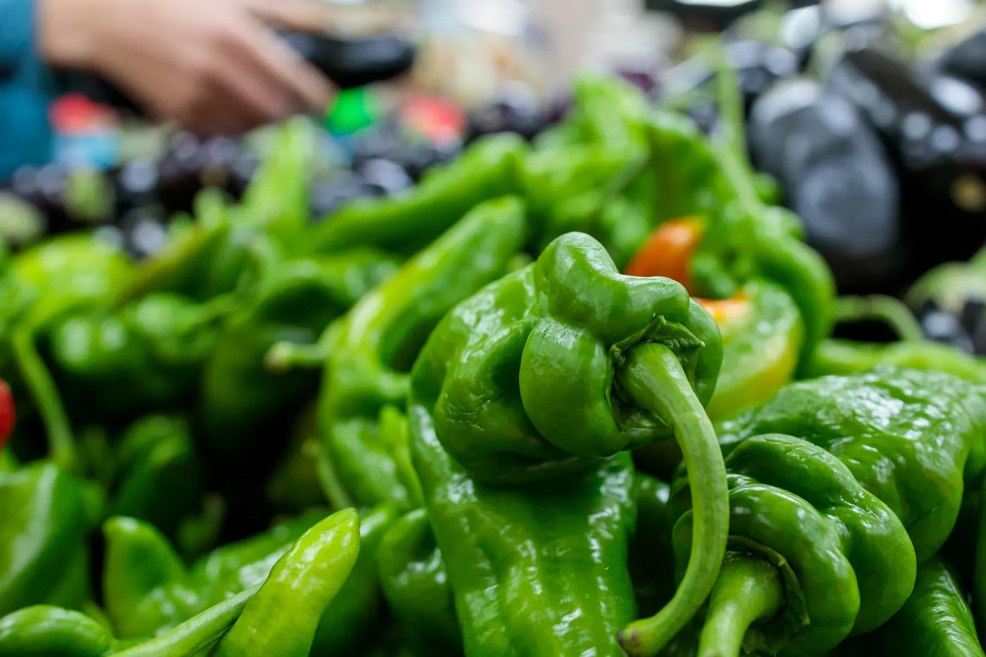 A heap of large green peppers at a market stall