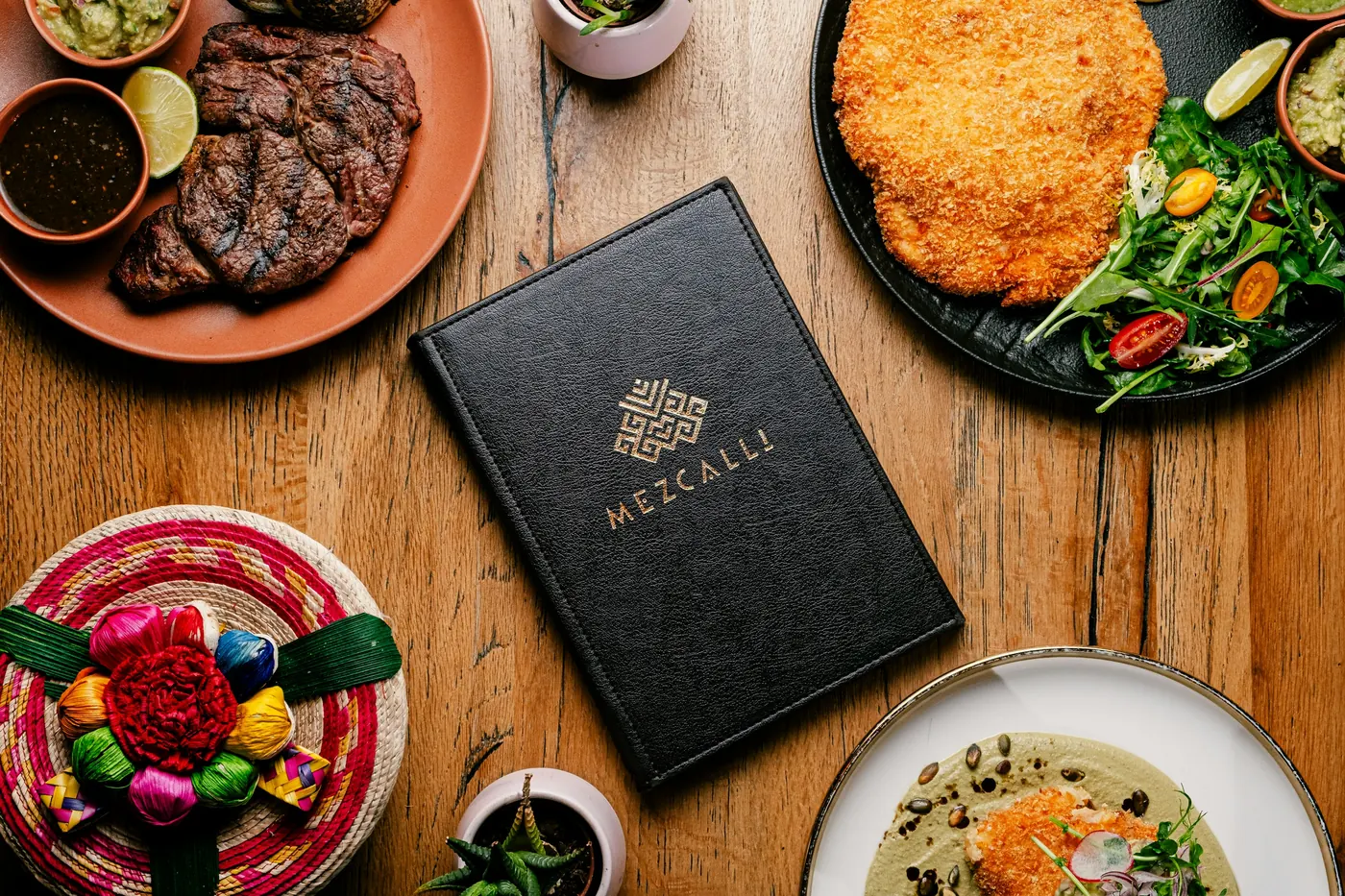 A dark menu folder surrounded by carefully plated dishes