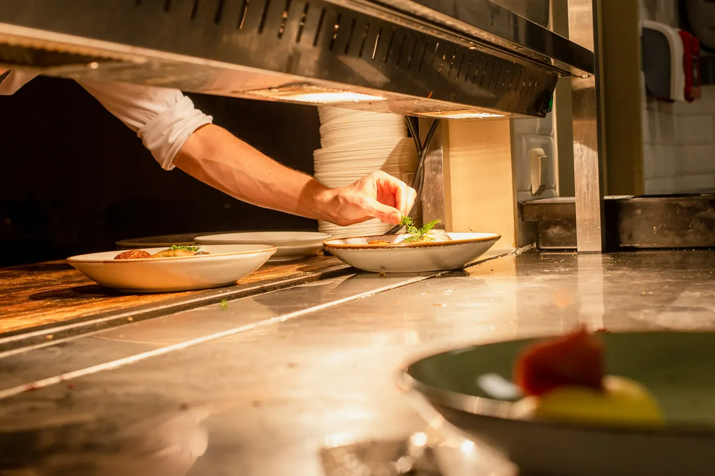 A finished plate waiting under a heat lamp at the pass