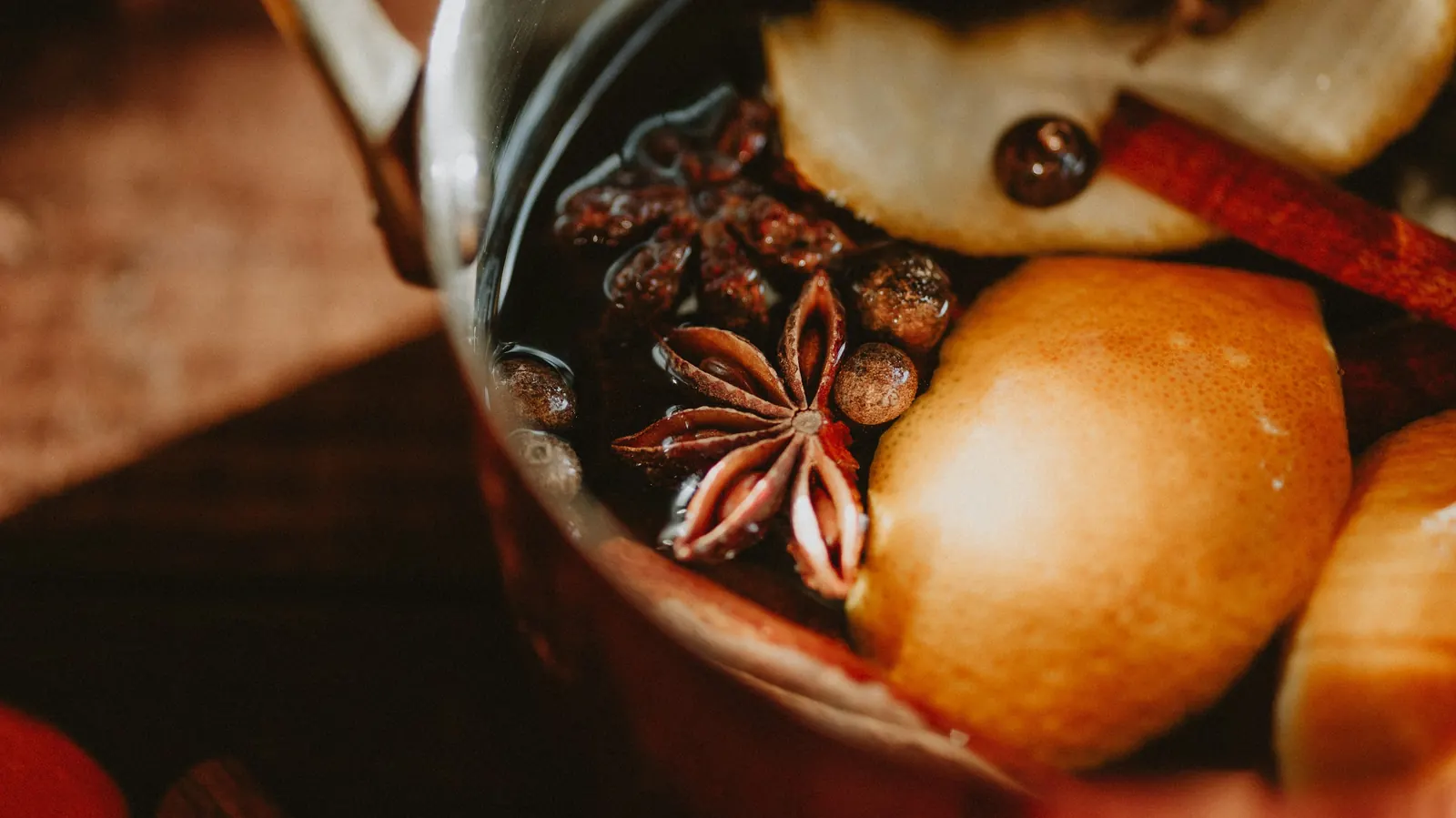 A pot of hot fruit punch with apple, star anise and cinnamon sticks