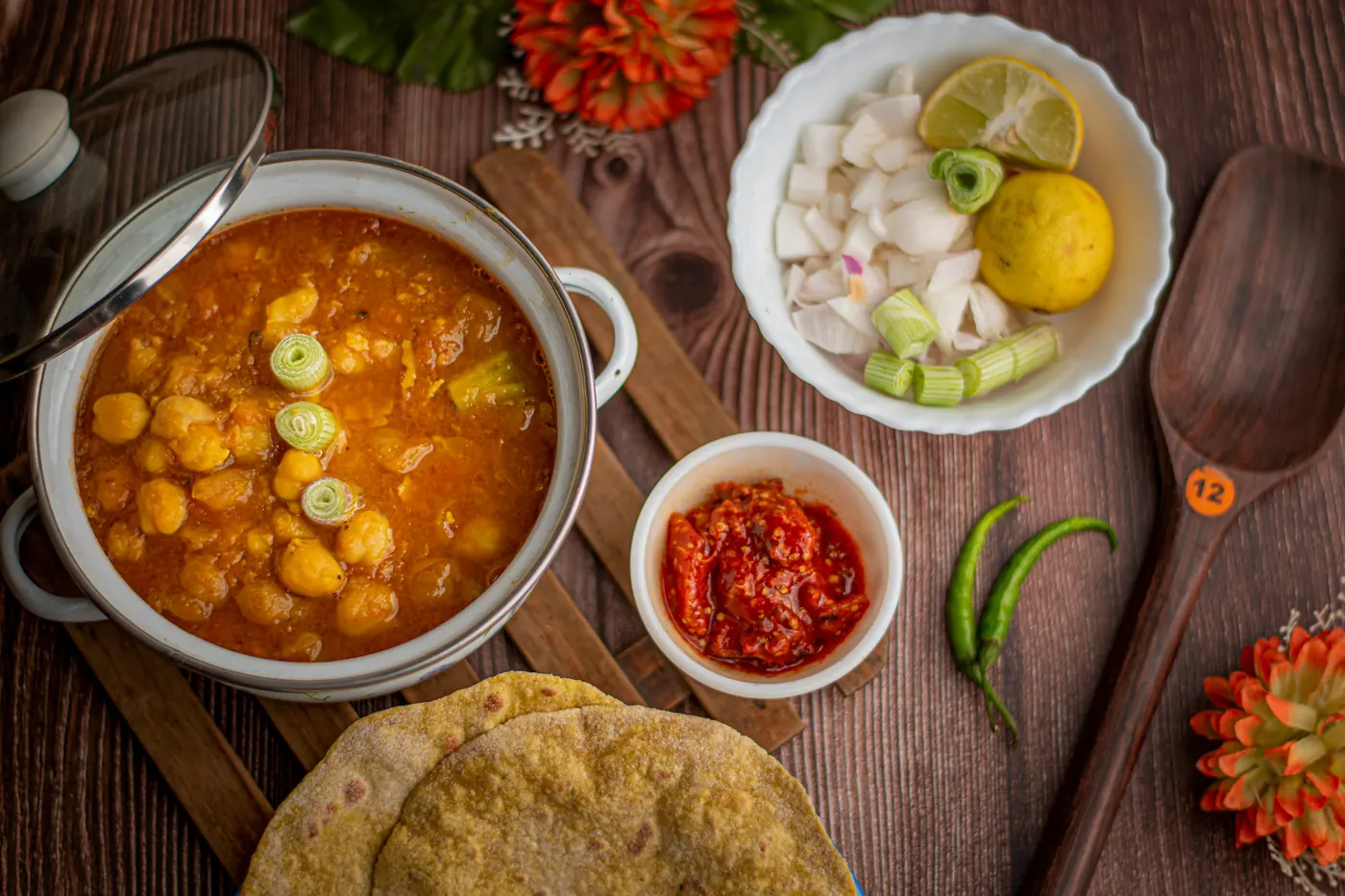 A pot of hominy soup surrounded by small bowls of garnishes and warm tortillas