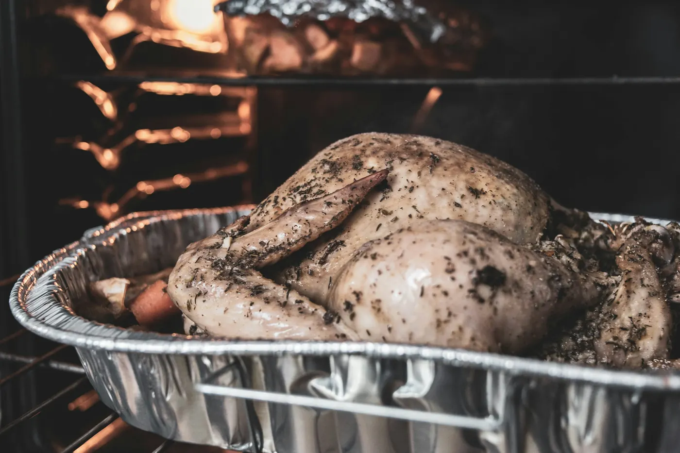 A whole roast browning in a roasting tin