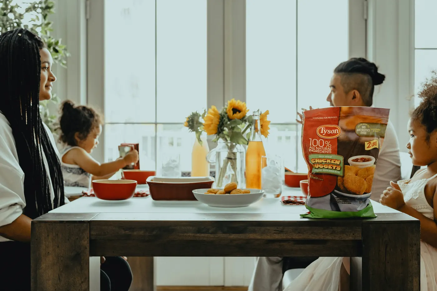 People sharing bowls of food around a wooden table