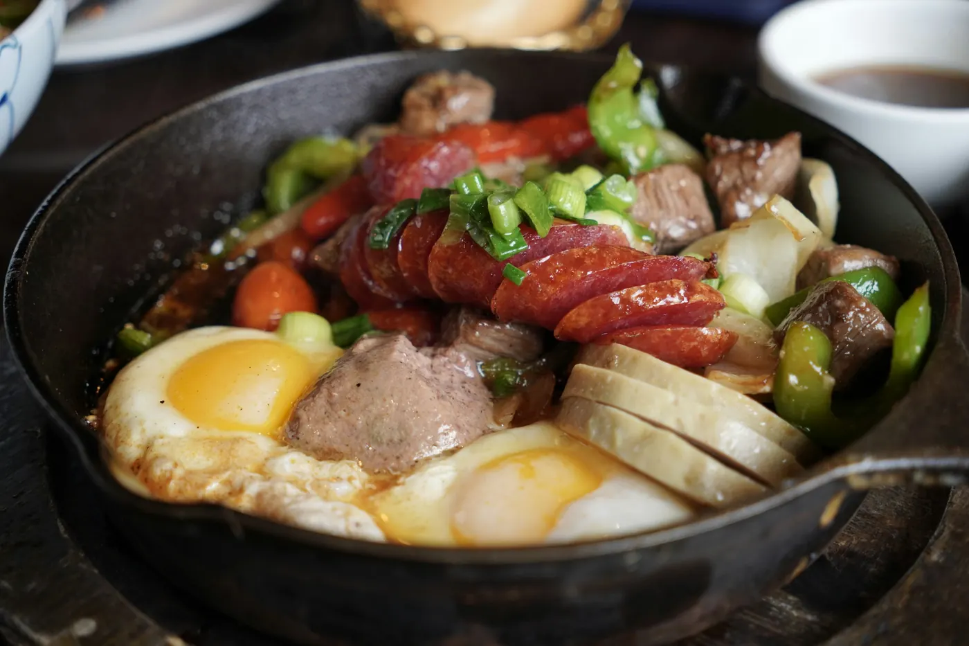 A skillet of stewed meat, peppers and eggs
