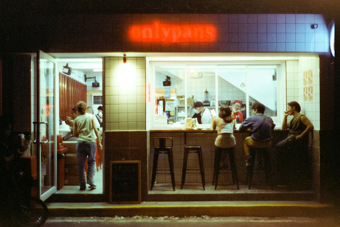 A small counter-service shop with customers seated at a bar