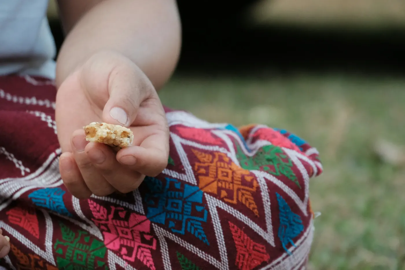 A small child's hand holding a piece of food