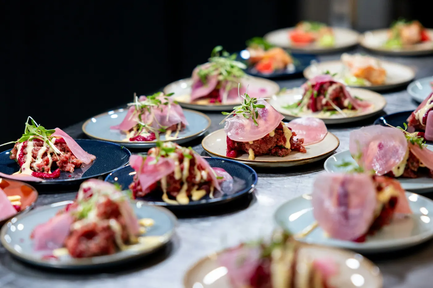 A long table covered in small plates of assorted food