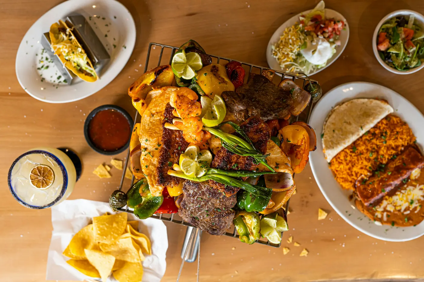 A wooden table crowded with plates of different dishes