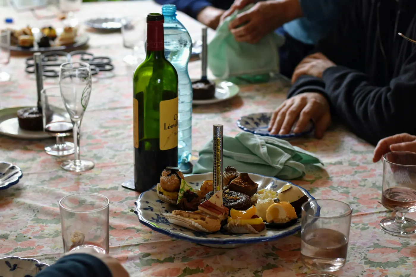 A table with wine, bread and several small plates being shared