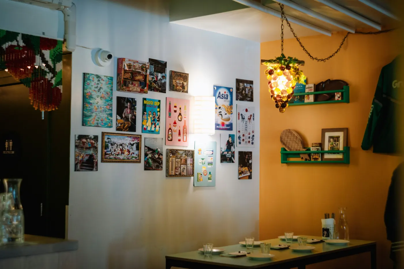 A warmly lit dining room with framed pictures and small tables