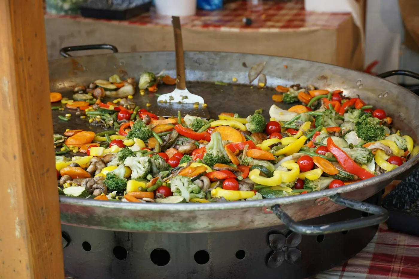 A wide pan of grilled meat mixed through sliced peppers and onions