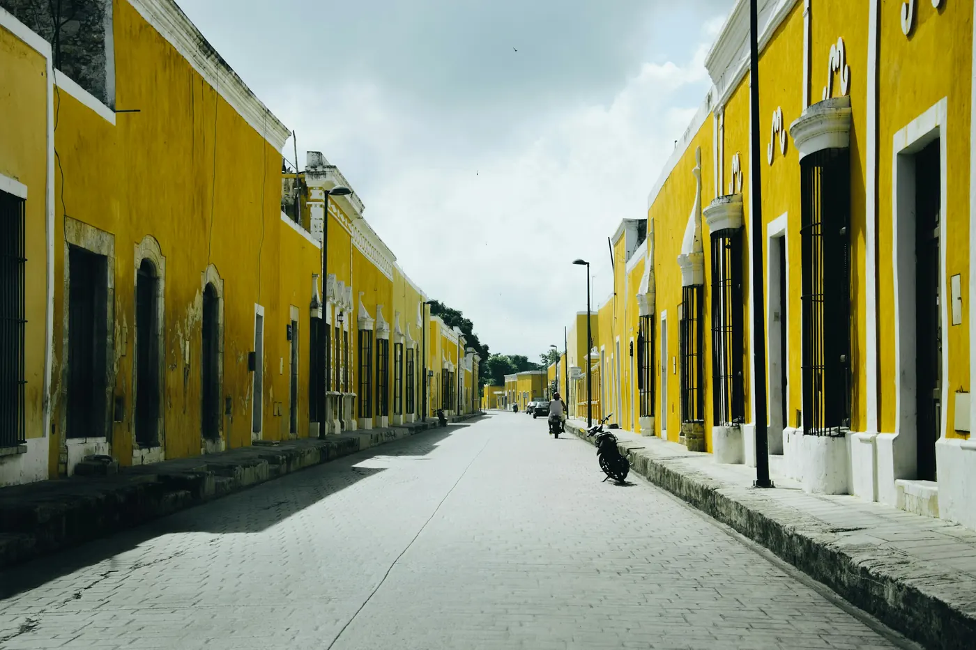 A long street of buildings painted in deep yellow under a blue sky