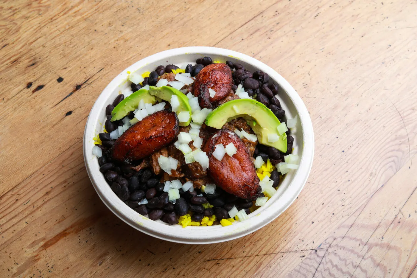 A bowl of beans and rice topped with avocado