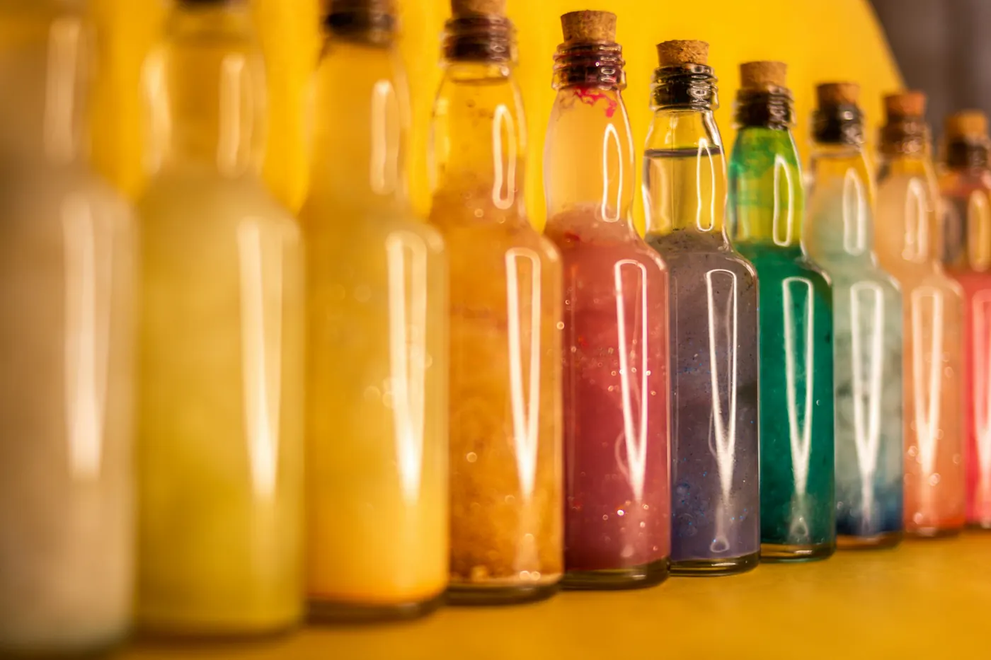 A row of bottles filled with brightly colored drinks