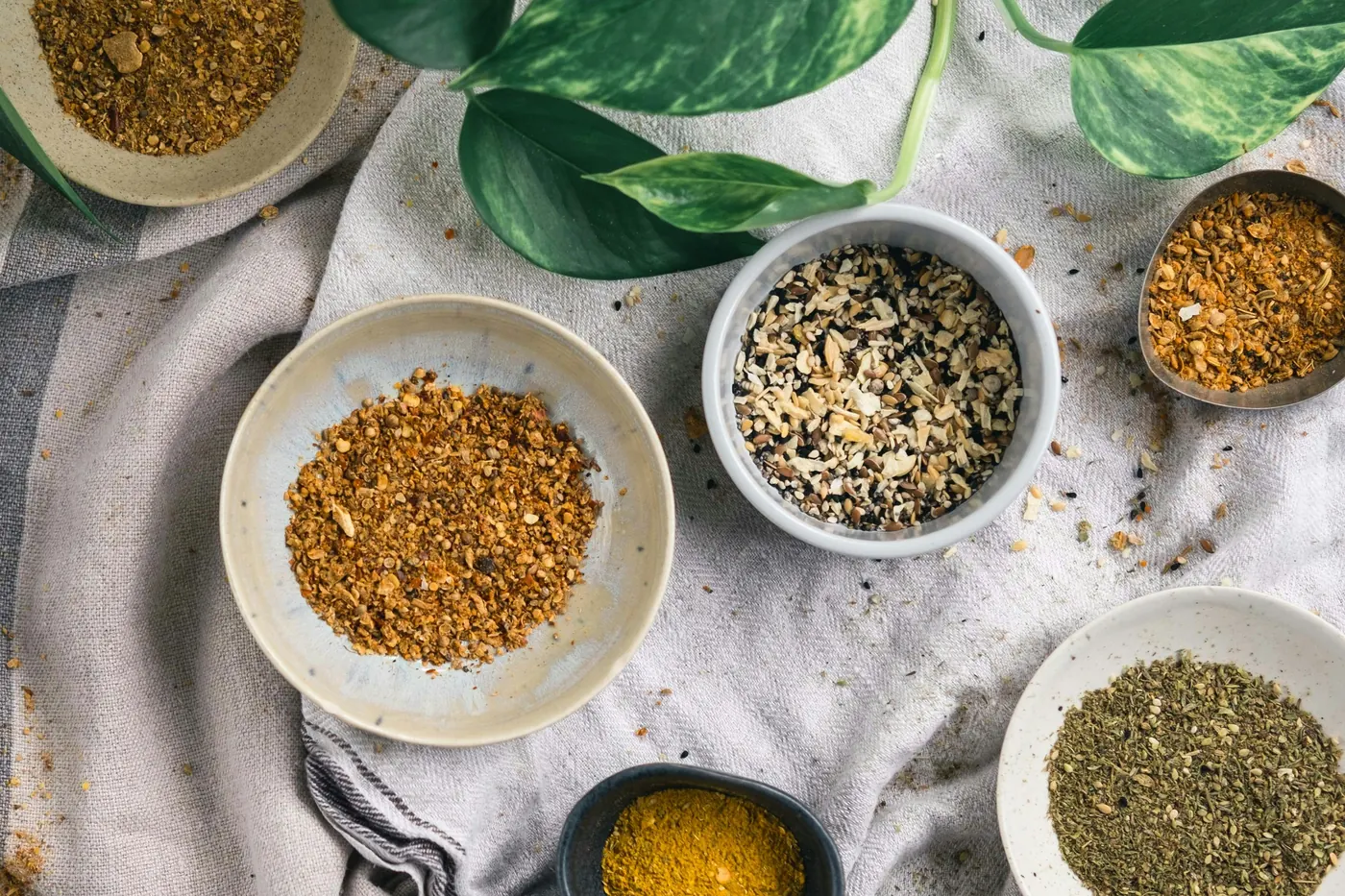 Small bowls of ground spices arranged on a linen cloth