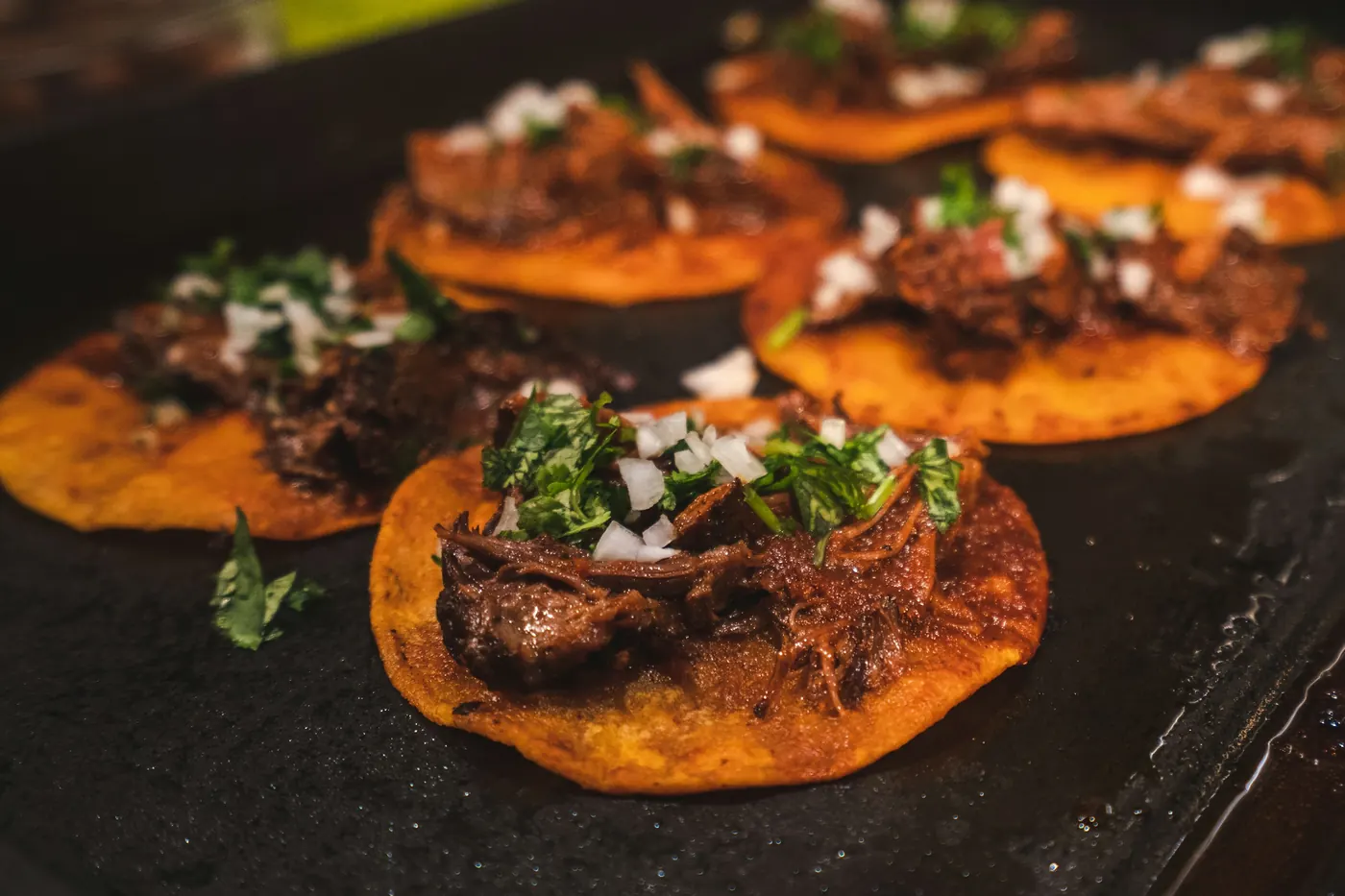 Braised meat served on small corn tortillas with onion and cilantro