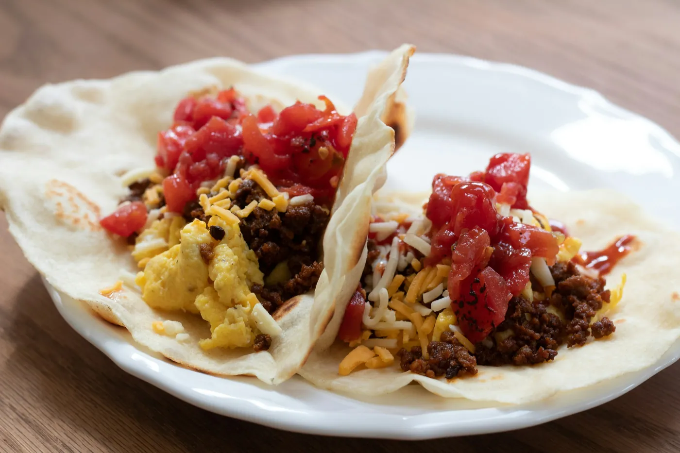 Breakfast tacos on soft flour tortillas filled with egg, potato and salsa