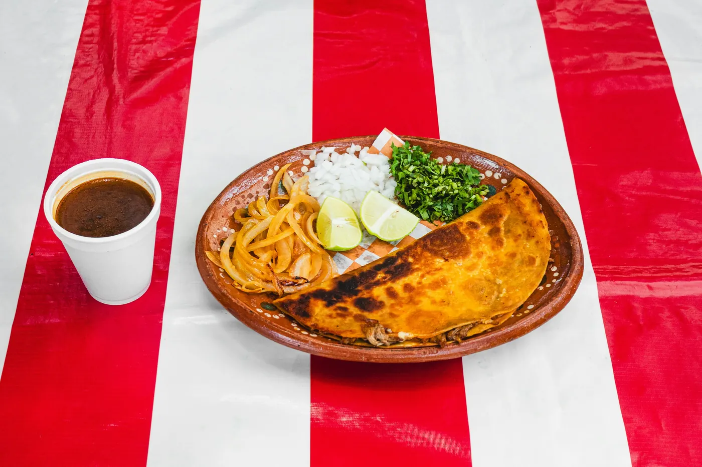 Cheese enchiladas served on a decorated clay plate with beans
