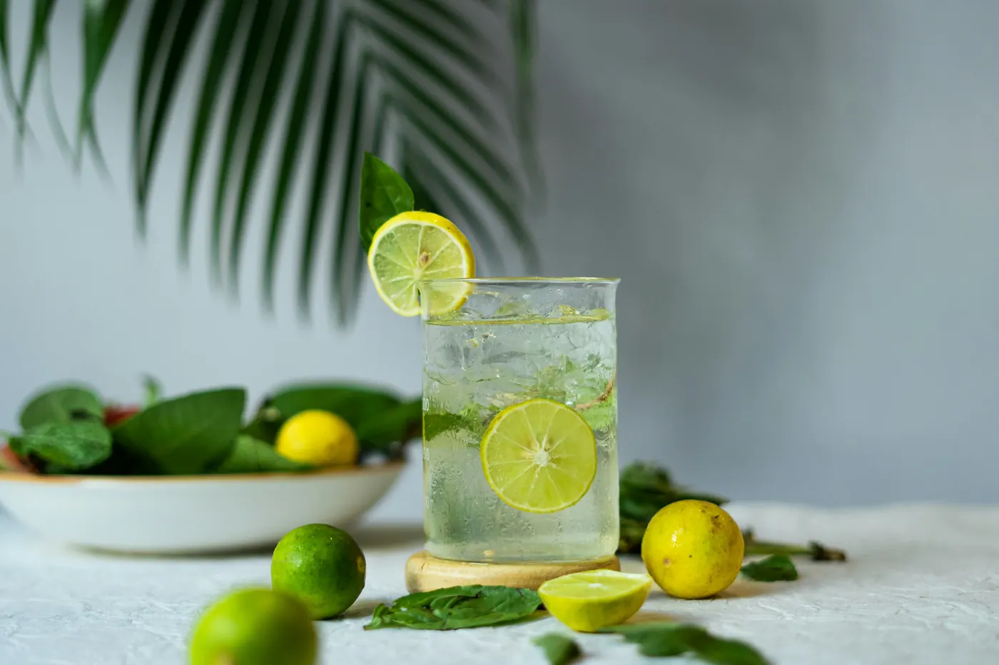 Tall cold drinks with fresh limes on a bright table