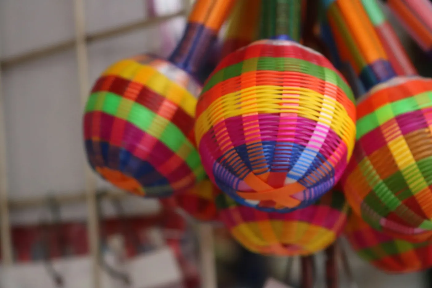 Brightly striped round pinatas hanging in a row