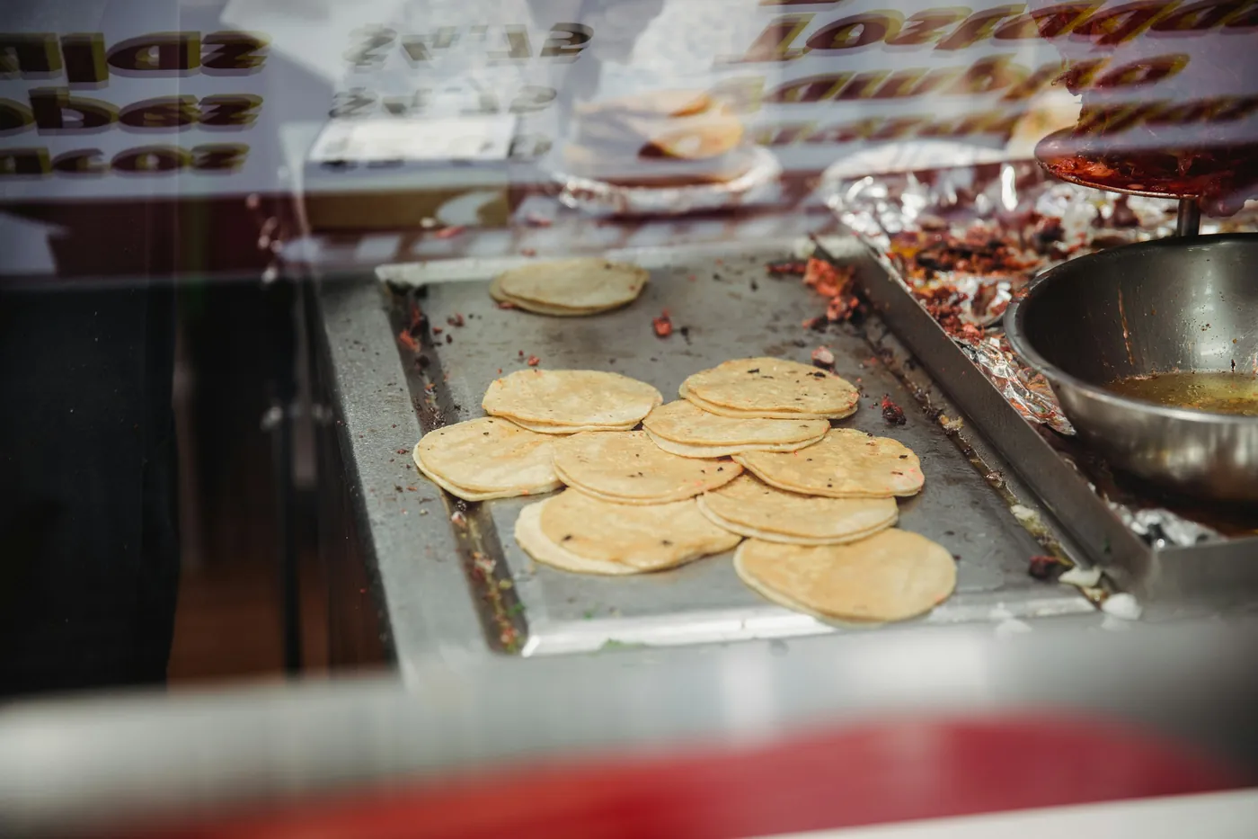 Corn tortillas cooking on a hot flat griddle