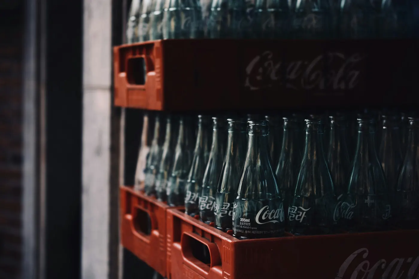 Stacked red crates filled with returnable glass cola bottles