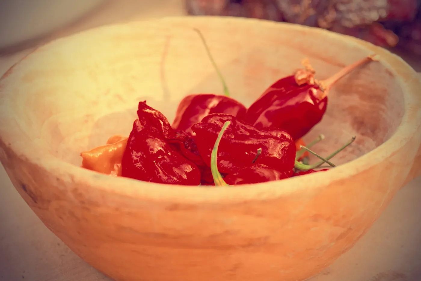 Whole dried red chiles resting in a pale clay bowl
