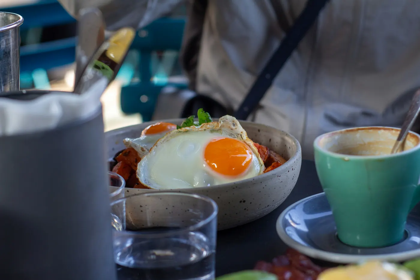 A pan of eggs on a table beside a cup of coffee