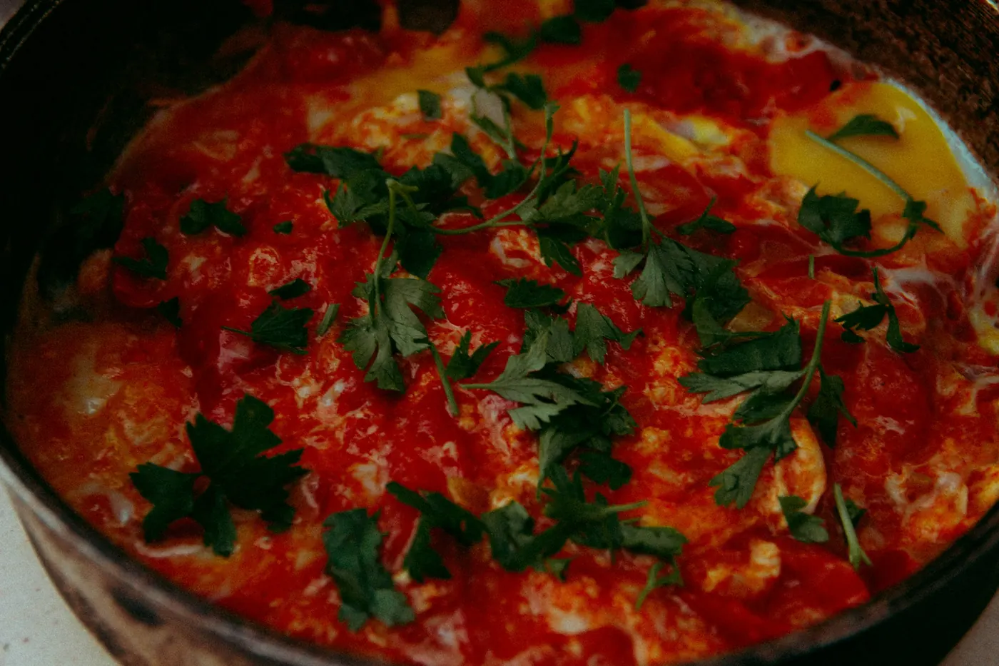Eggs cooked into a thick red sauce and scattered with herbs