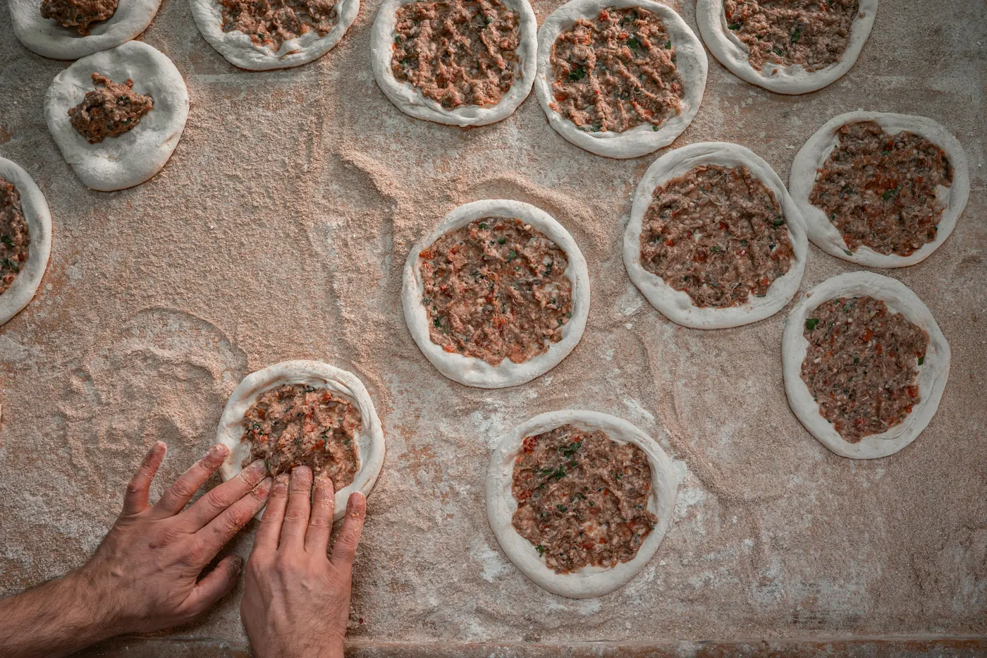 Spoonfuls of filling placed onto rows of dough rounds