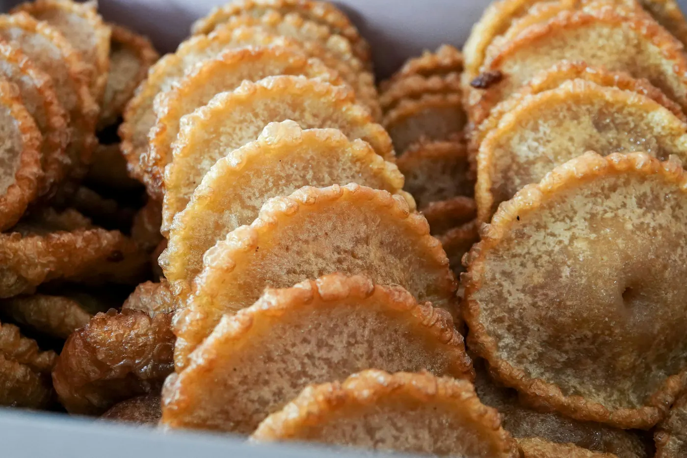 Round crinkled discs of fried dough dusted with sugar and cinnamon