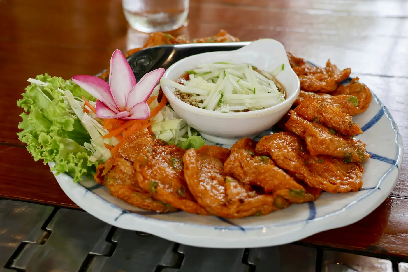 A plate of fried fish fillets arranged with salad and garnish