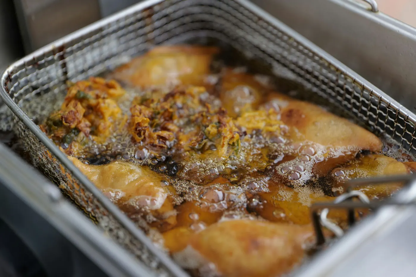 Fried items draining in a metal basket