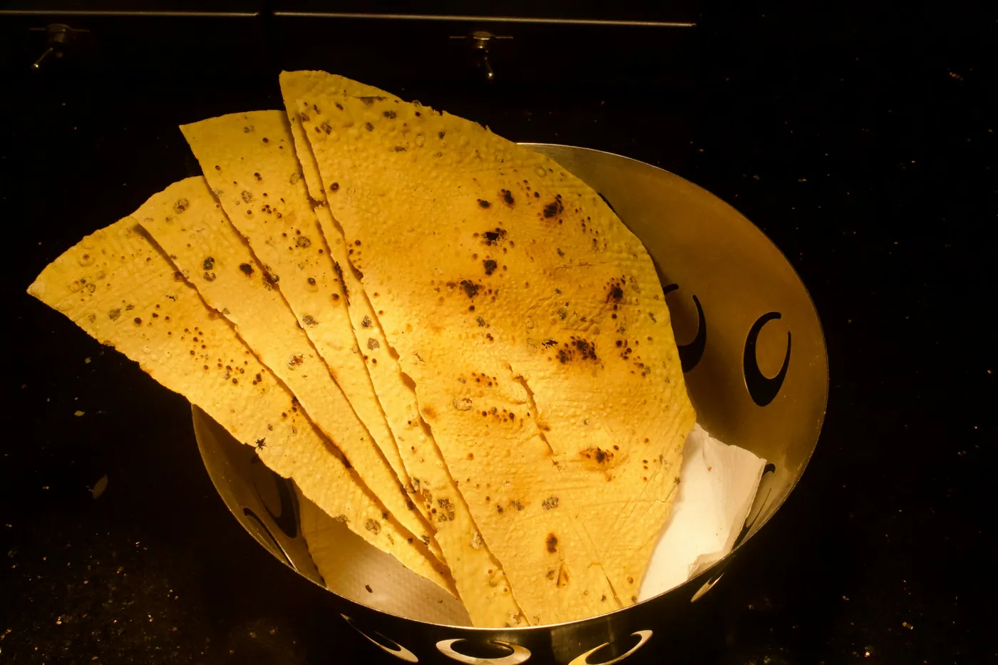 Fried tortilla wedges served in a metal bowl