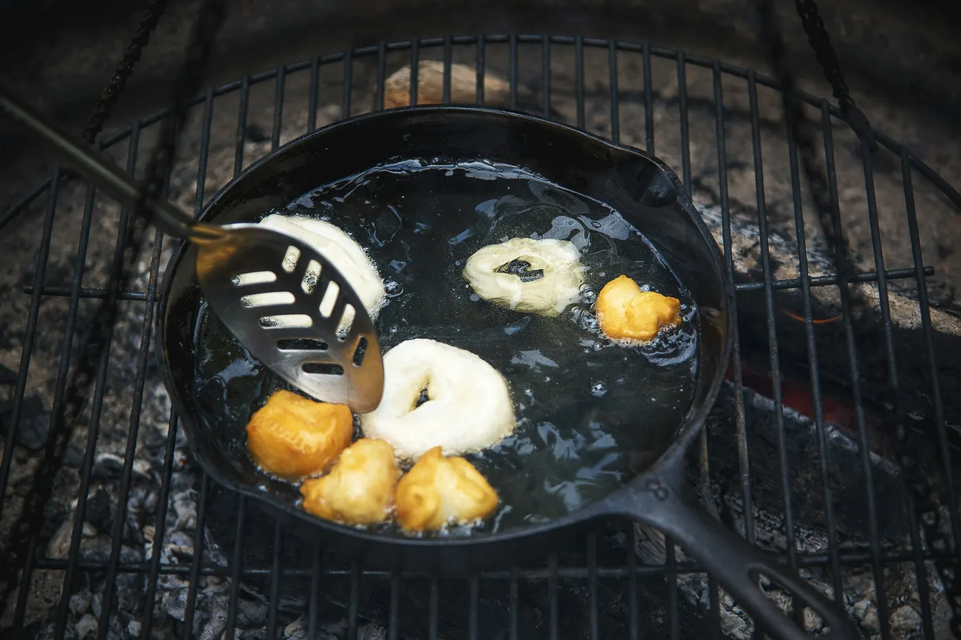 Food frying in oil in a heavy skillet over heat
